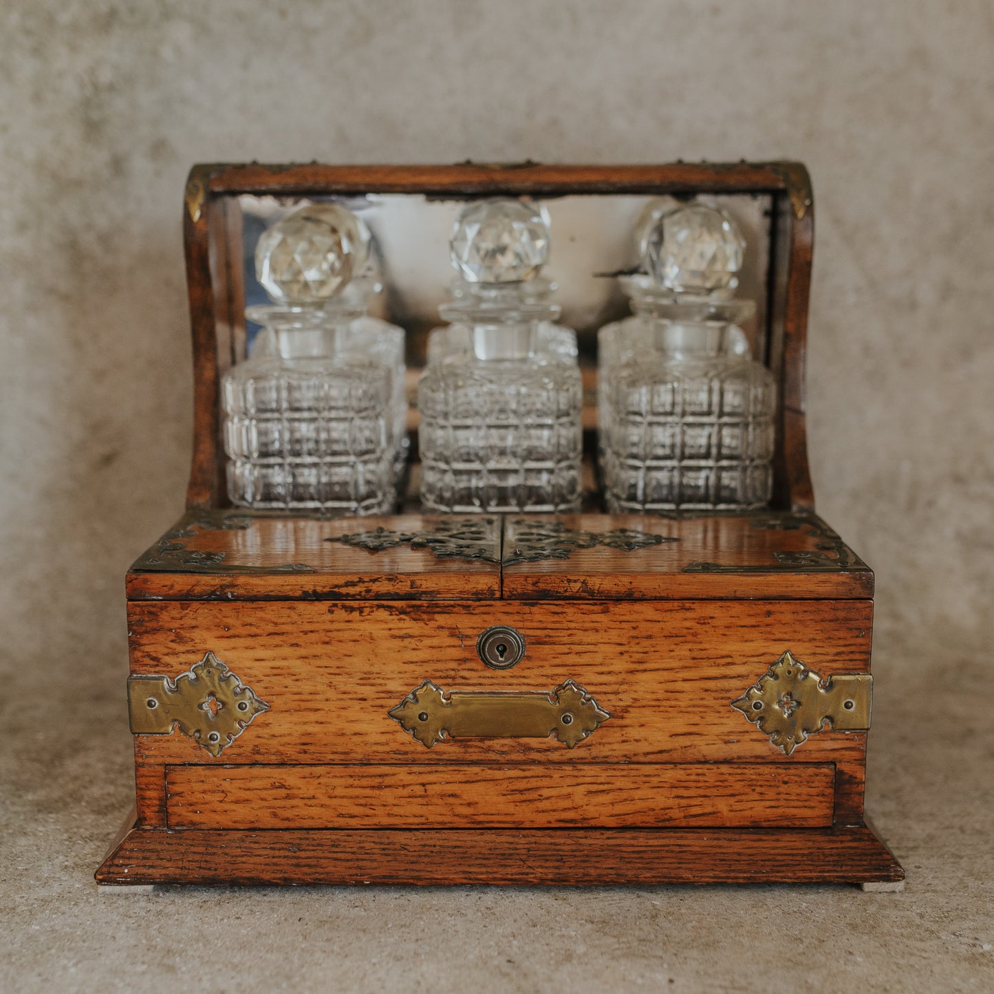 Antique Oak and Brass Inlaid Tantalus with Three Cut Crystal Decanters & Secret Game Drawer
