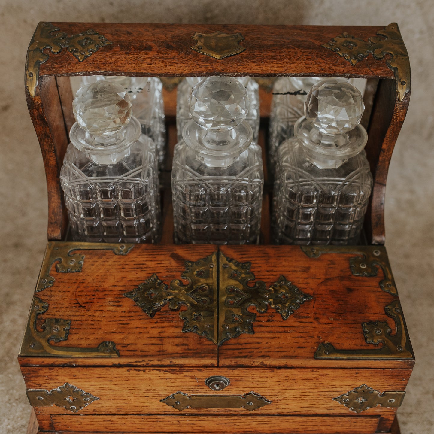 Antique Oak and Brass Inlaid Tantalus with Three Cut Crystal Decanters & Secret Game Drawer