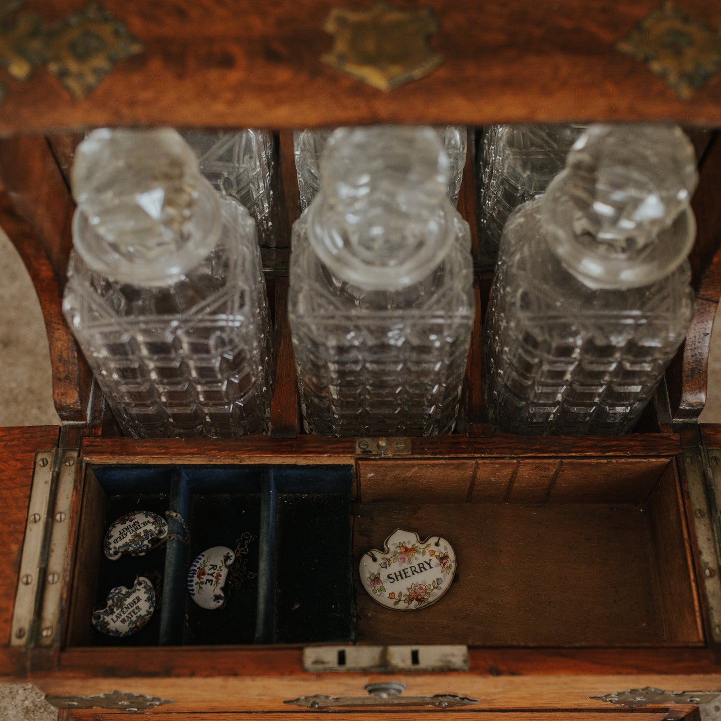 Antique Oak and Brass Inlaid Tantalus with Three Cut Crystal Decanters & Secret Game Drawer