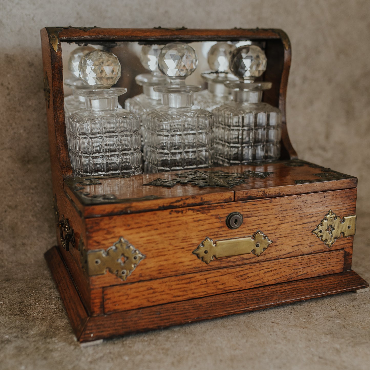 Antique Oak and Brass Inlaid Tantalus with Three Cut Crystal Decanters & Secret Game Drawer
