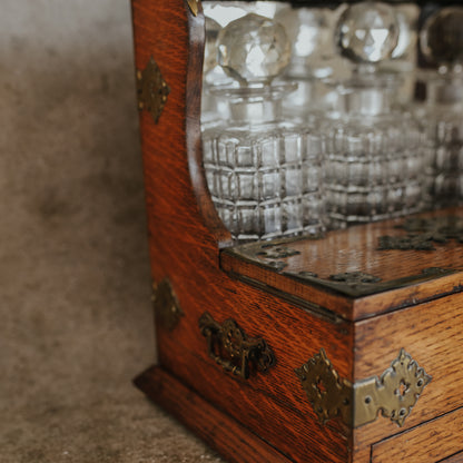 Antique Oak and Brass Inlaid Tantalus with Three Cut Crystal Decanters & Secret Game Drawer