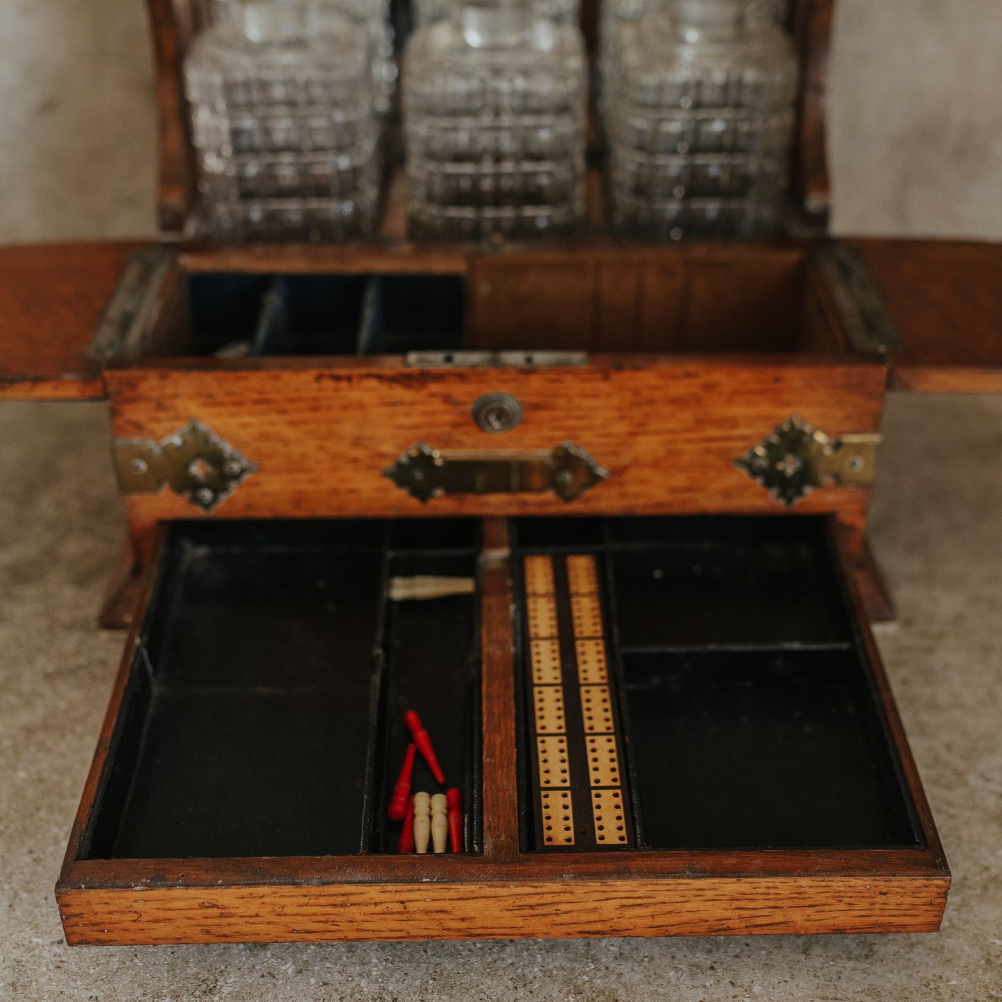 Antique Oak and Brass Inlaid Tantalus with Three Cut Crystal Decanters & Secret Game Drawer